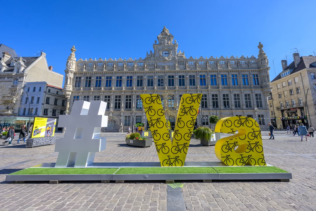 [🚴‍♂️💛 𝗟𝗮 𝗽𝗹𝗮𝗰𝗲 𝗱’𝗔𝗿𝗺𝗲𝘀 𝗲𝗻 𝗷𝗮𝘂𝗻𝗲 #MaVilleEnJaune ! 💛🚴‍♂️]
La place d’Armes se pare de jaune pour célébrer le Le Tour de France ! Des fanions, des fleurs 🌼, des passes-têtes et une expo ont envahi la place pour rendre hommage à cette course légendaire. 🚴‍♂️✨

🚴‍♂️💛 Vous pourrez aussi découvrir le parcours que les coureurs emprunteront 𝗹𝗲 𝟳 𝗷𝘂𝗶𝗹𝗹𝗲𝘁 𝗽𝗿𝗼𝗰𝗵𝗮𝗶𝗻, en traversant notre ville. Sans oublier la présence du #𝗩𝗮 pour des photos inoubliables. 
N’oubliez pas de nous partager vos plus beaux clichés 📸😉@𝘃𝗮𝗹𝗲𝗻𝗰𝗶𝗲𝗻𝗻𝗲𝘀_𝗺𝗮𝘃𝗶𝗹𝗹𝗲 📸

𝗟’𝗮𝗺𝗯𝗶𝗮𝗻𝗰𝗲 𝗱𝘂 𝗧𝗼𝘂𝗿 𝗲𝘀𝘁 𝗱𝗲́𝗷𝗮̀ 𝗹𝗮̀ ! 🚴‍♀️🎉 
De nombreuses animations sont prévues dans les prochaines semaines. Pour ne rien rater de cet événement 👉 https://www.valenciennes.fr/decouvrir-la-ville/ses-loisirs-sportifs/tour-de-france/ 

𝗩𝗶𝘃𝗲 𝗹𝗲 𝗧𝗼𝘂𝗿 𝗮̀ 𝗩𝗮𝗹𝗲𝗻𝗰𝗶𝗲𝗻𝗻𝗲𝘀 ! 💛🚴‍♂️